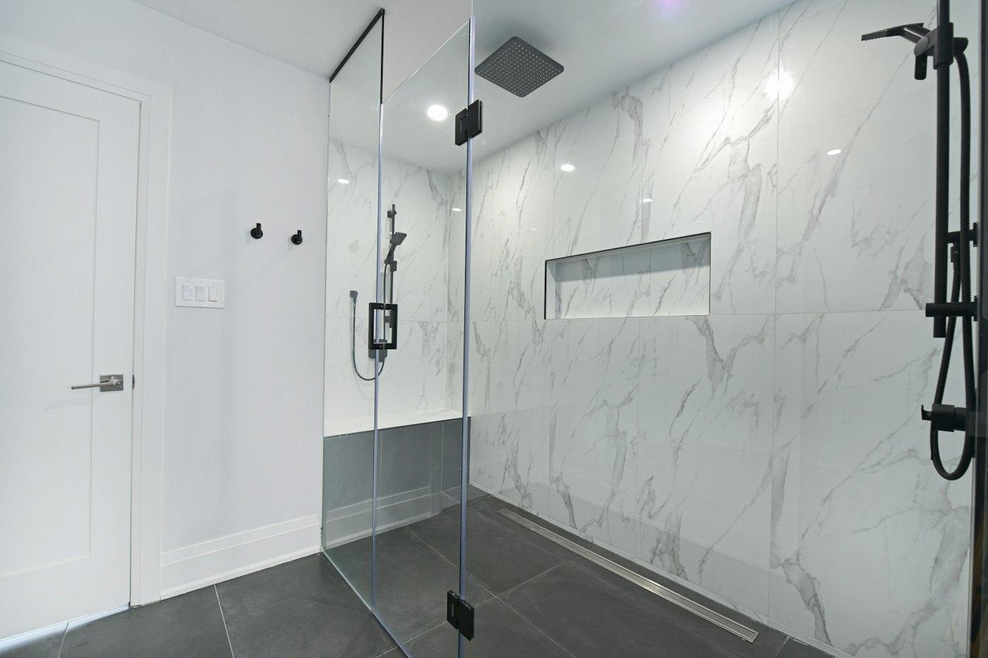 Frameless walk-in shower with marble walls